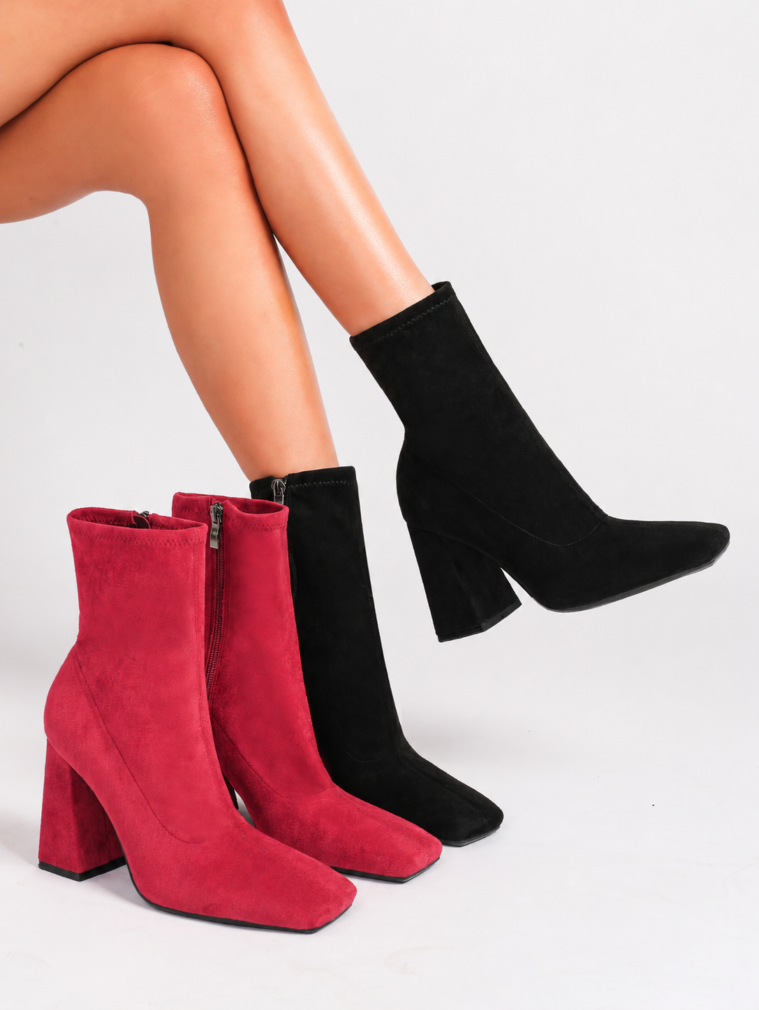 Moncelia red and black suede square toe flared heel booties, both colours worn seated, women's sizes 5 to 11.5