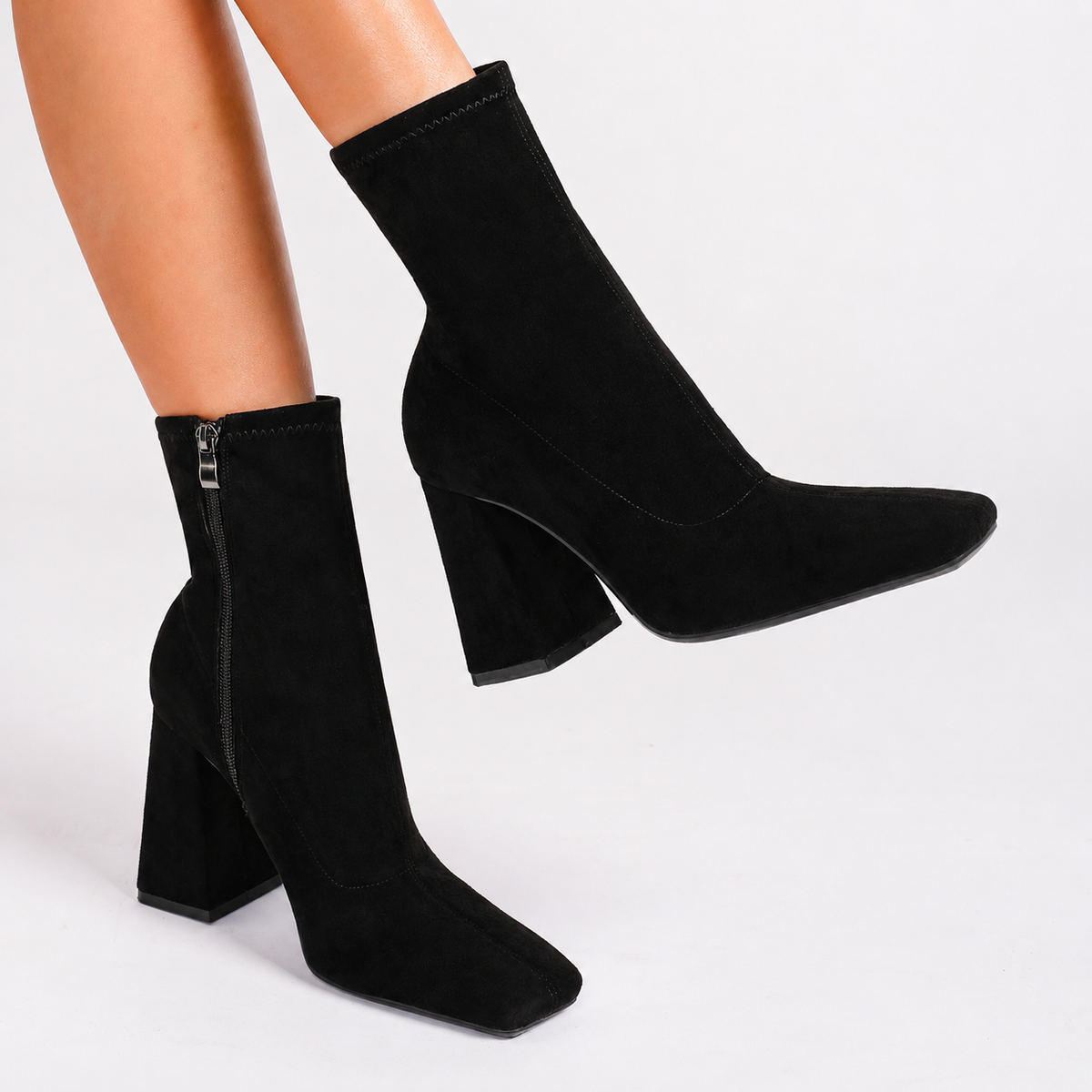 Moncelia black suede square toe flared heel booties, side view on model showing zip, women's sizes 5 to 11.5
