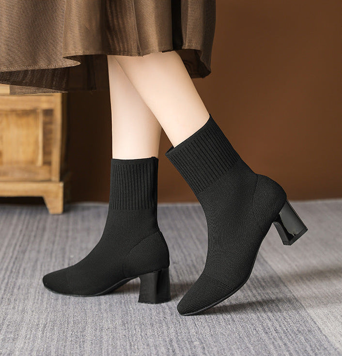 Moncelia black knit sock ankle boots, side view on model with a midi skirt, women's sizes 5.5 to 12