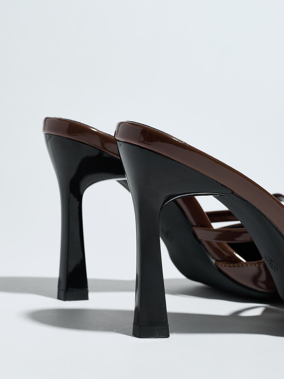 Moncelia brown bow pointed toe heeled mules, back view showing flared black heels, women's sizes 5 to 12