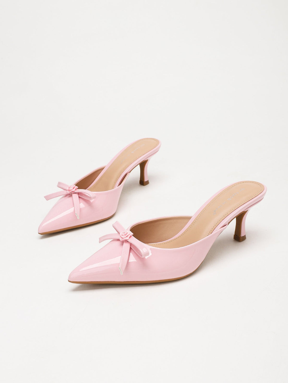 Moncelia pink bow pointed toe curved heel mules, pair shown at an angle showing bow, women's sizes 5 to 11.5