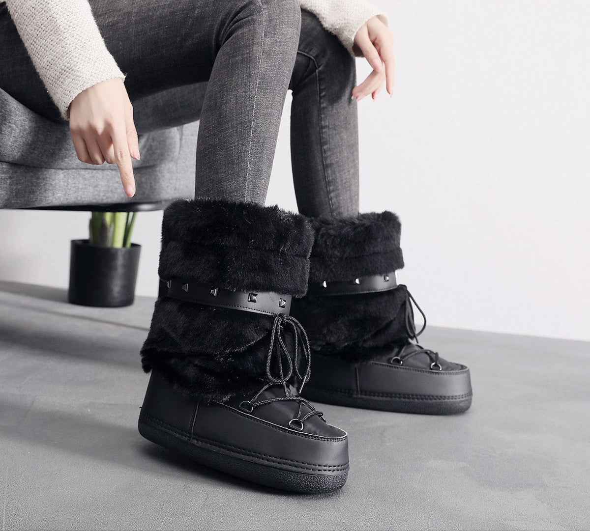 Moncelia black faux fur studded platform snow boots, worn seated with grey jeans, women's sizes 5.5 to 9