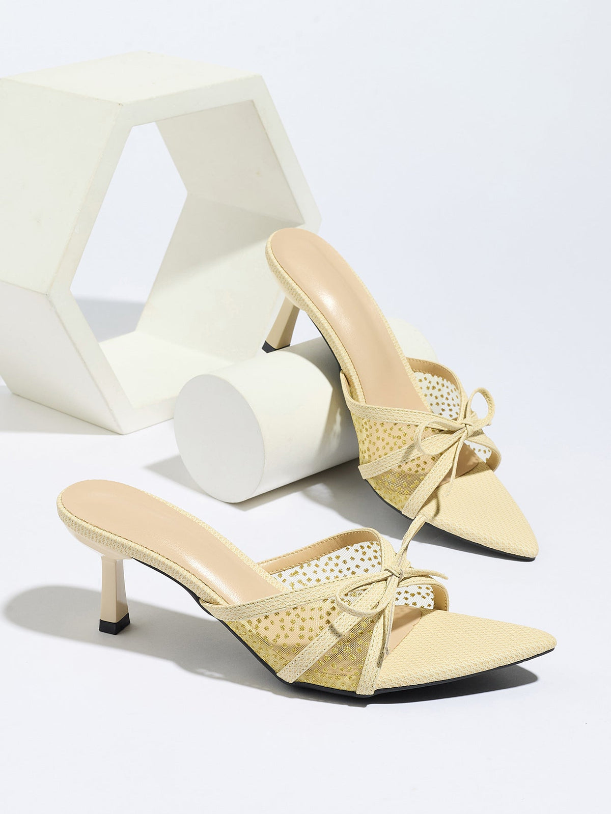 Moncelia apricot bow mesh pointed toe heeled mules, pair styled on a white display, women's sizes 5 to 12