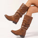 Moncelia camel slouchy pull-on mid-calf boots, worn on model with legs crossed, women's sizes 5.5 to 11.5
