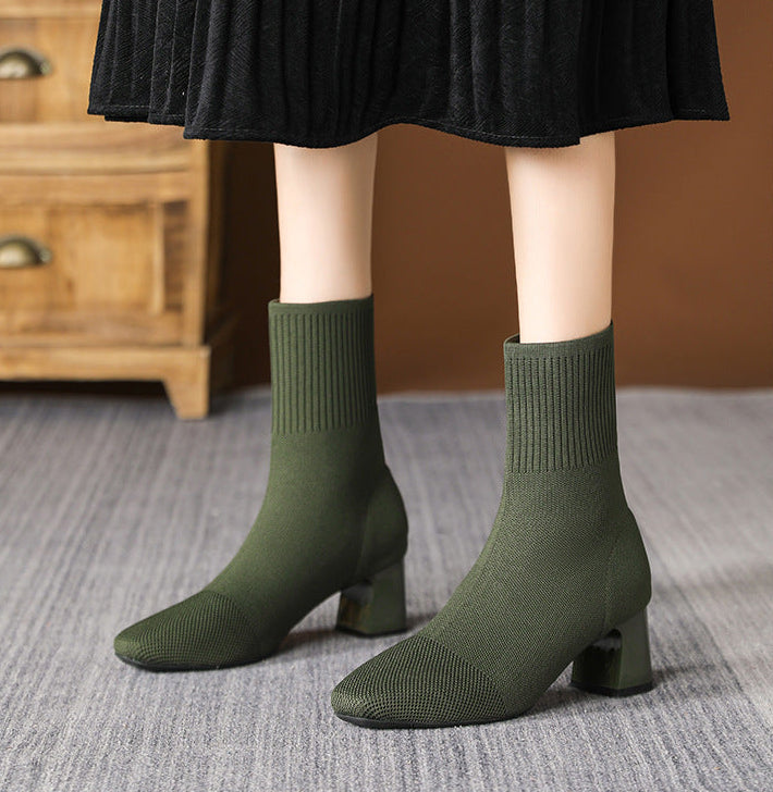 Moncelia green knit sock ankle boots, front view on model with a pleated skirt, women's sizes 5.5 to 12