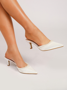 Moncelia ivory pearl trim satin mules, worn on model with one foot raised, women's sizes 5 to 11.5