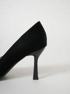 Moncelia black folded plate pointed toe pumps, close-up of the slim stiletto heel, women's sizes 5.5 to 10.5