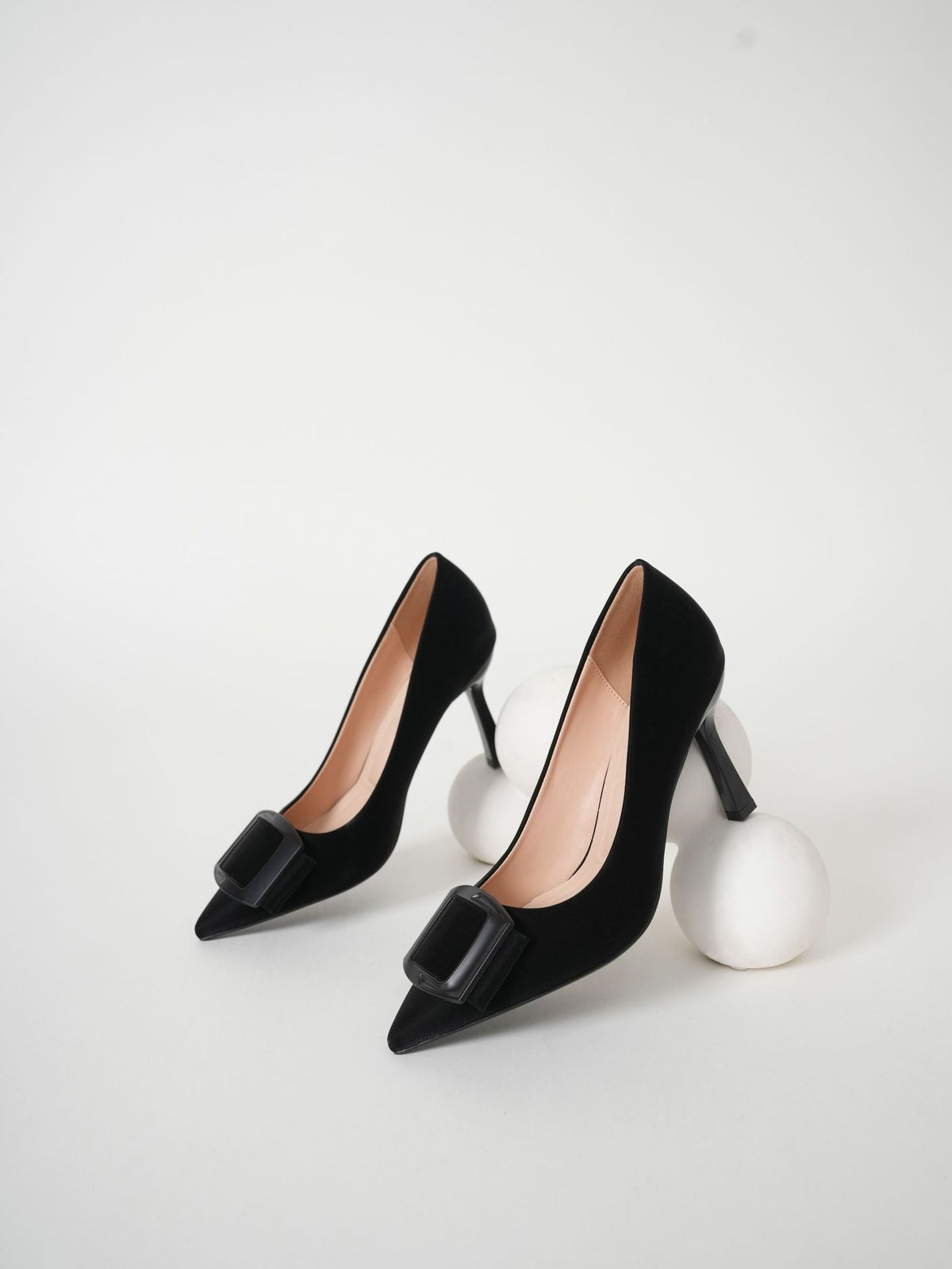 Moncelia black folded plate pointed toe pumps, pair shown from the side, women's sizes 5.5 to 10.5