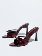 Moncelia burgundy bow pointed toe heeled mules, patent pair shown from the side, women's sizes 5 to 12