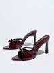Moncelia burgundy bow pointed toe heeled mules, patent pair shown from the side, women's sizes 5 to 12