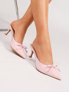 Moncelia pink bow pointed toe curved heel mules, worn on model, front view of toes, women's sizes 5 to 11.5