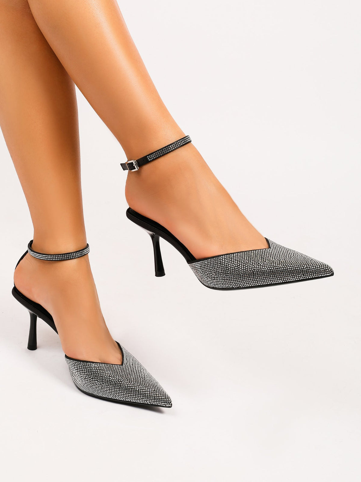 Moncelia black crystal paved pointed toe mules, worn on model with ankle strap, women's sizes 5 to 11.5