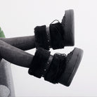 Moncelia black faux fur studded platform snow boots, worn on model with legs raised, women's sizes 5.5 to 9