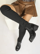 Moncelia black ribbed knit over-the-knee boots, leg raised showing lug platform sole, women's sizes 5.5 to 12