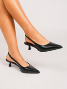 Moncelia black pointed toe slingback spool heels, worn on model, side view, women's sizes 5 to 11.5